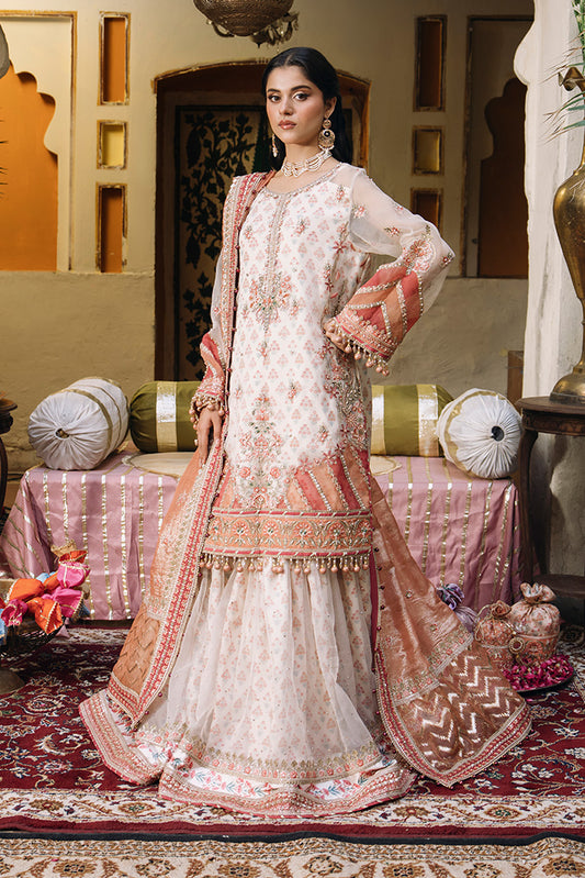 Model wearing an ivory Nikkah dress with peach floral embroidery, sheer embellished sleeves, flared sharara trousers, and a peach dupatta with ornate borders.