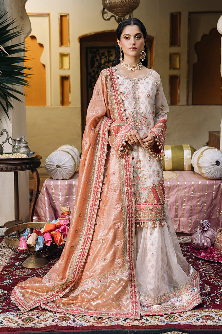 Model wearing an ivory and peach Nikkah dress with delicate floral embroidery, embellished sleeves, a flared sharara, and a richly bordered peach dupatta.