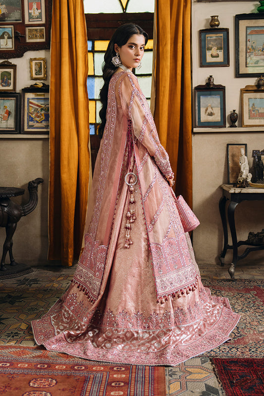 Model wearing a dusty rose Nikkah dress shown from the side and back, featuring intricate silver-pink embroidery, embellished panels, tassel details, a flared hem, and a matching potli bag.
