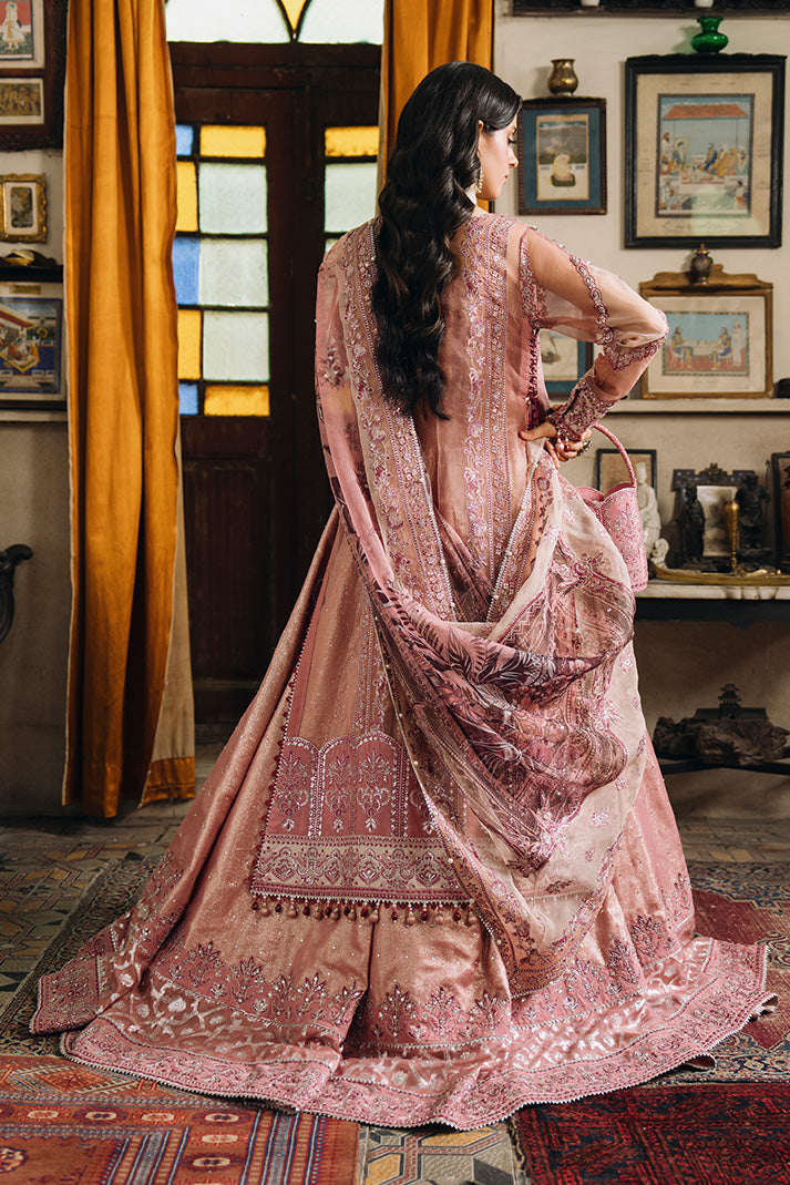 Rear view of a dusty rose Nikkah dress featuring intricate embroidery, a flowing embellished dupatta, detailed hem borders, and a coordinated bridal potli bag.