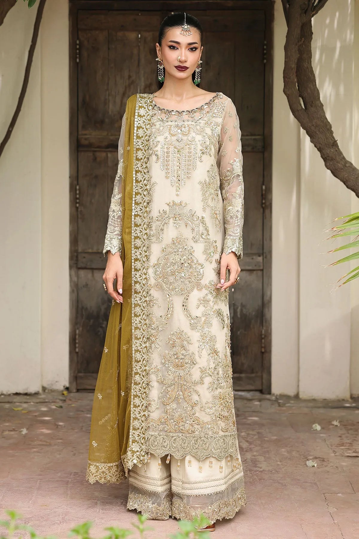 Woman wearing a traditional outfit with a green dupatta in an outdoor setting.